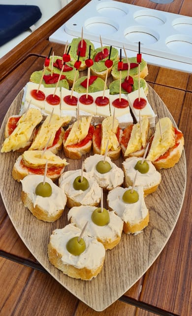 Barcelona: Sailing Tour with Spanish Tapas and Drinks - Tapas, snacks, and drinks aboard Bombon