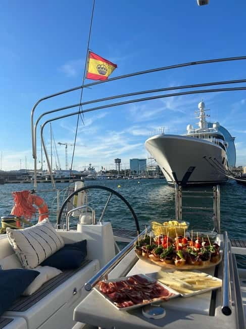 Barcelona: Sailing Tour with Tapas, Drinks and Swim Stop - Passing Barceloneta with Barcelona behind you