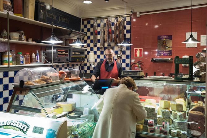 Madrid Tapas & Wine Tasting Walking Tour – Small Group Local Bars - Plaza del Ángel and a wine shop behind the bottles